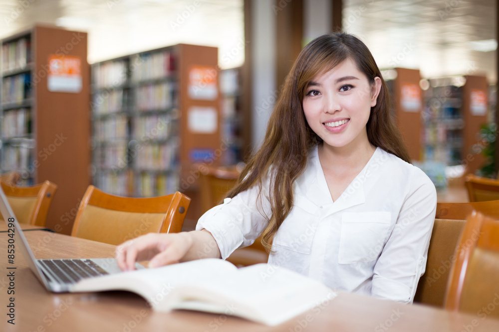 亚洲美女女学生在图书馆使用笔记本电脑