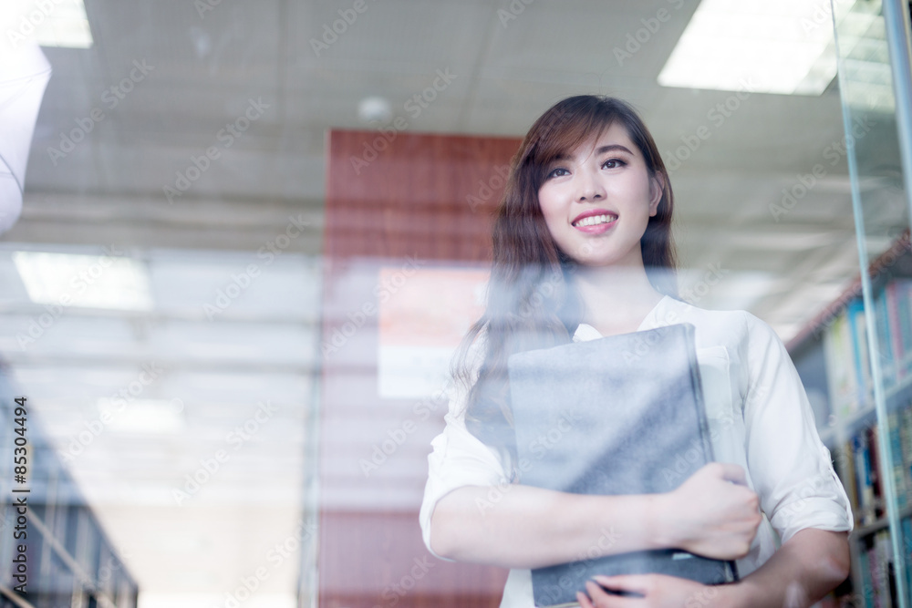 亚洲美女女学生在图书馆拿书