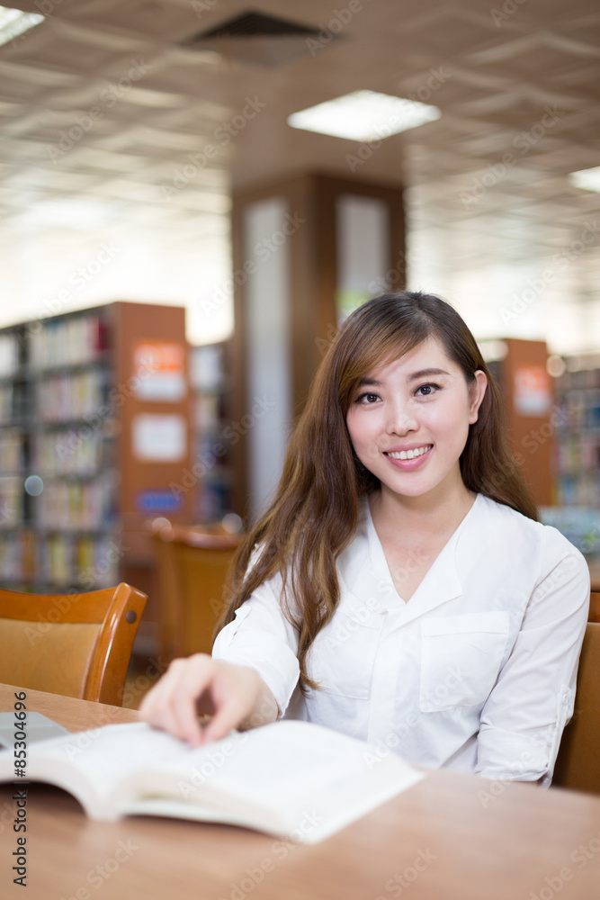 Asian beautiful female student using laptop in library