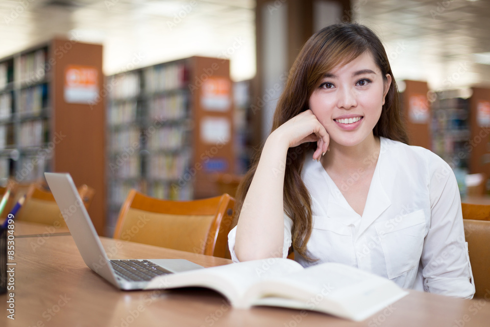 亚洲美女女学生在图书馆使用笔记本电脑