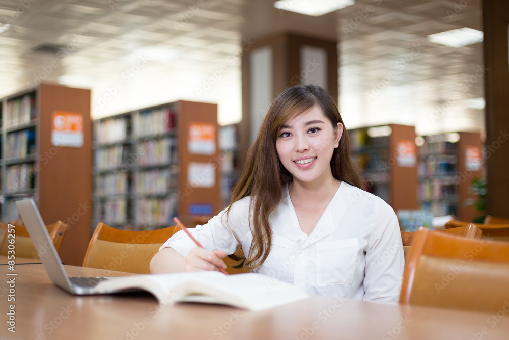 亚洲美女女学生在图书馆使用笔记本电脑