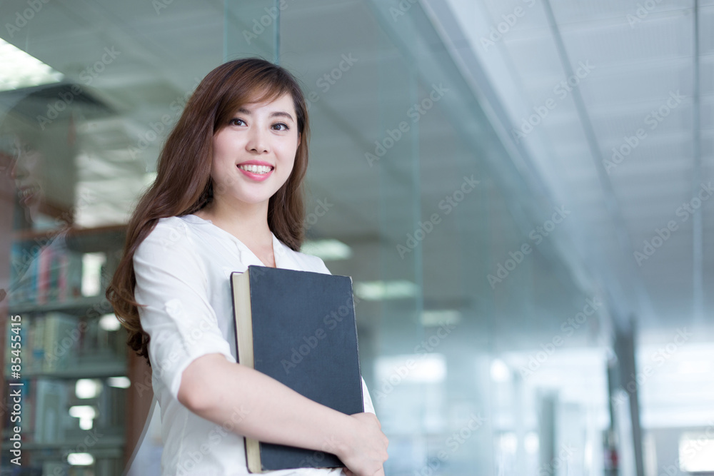 图书馆里拿着书的亚洲美女女学生