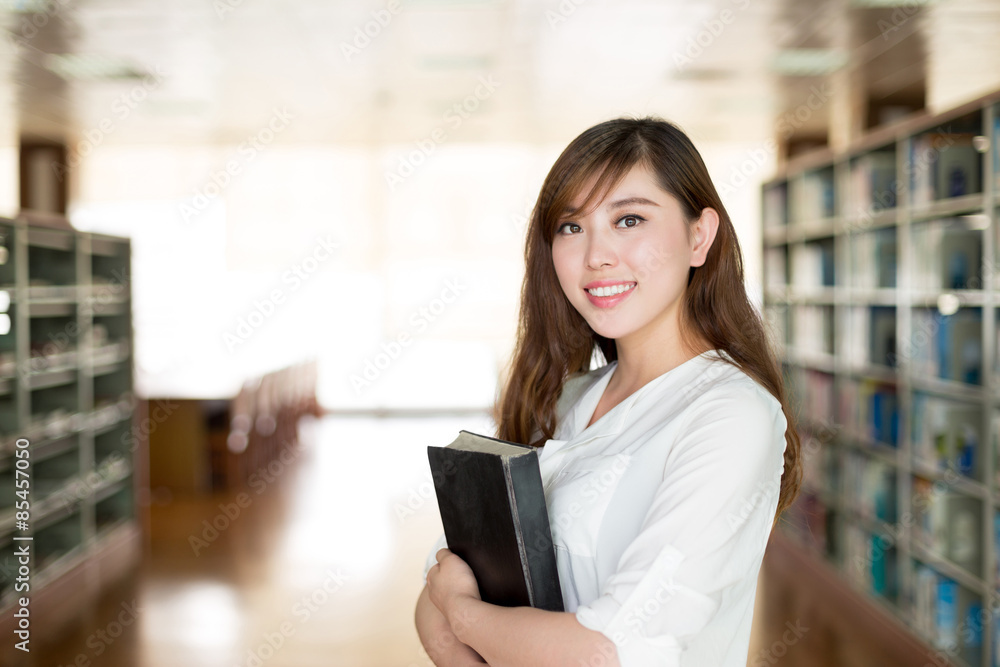 亚洲美女女学生在图书馆拿书