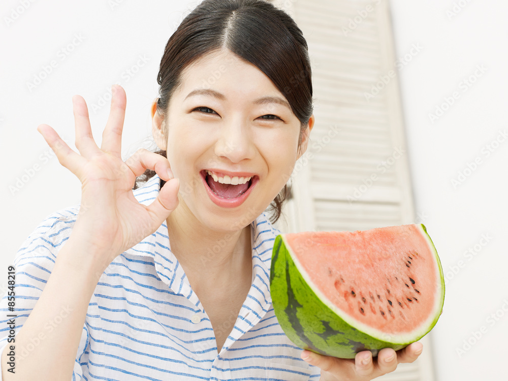 部屋で西瓜を食べる女性