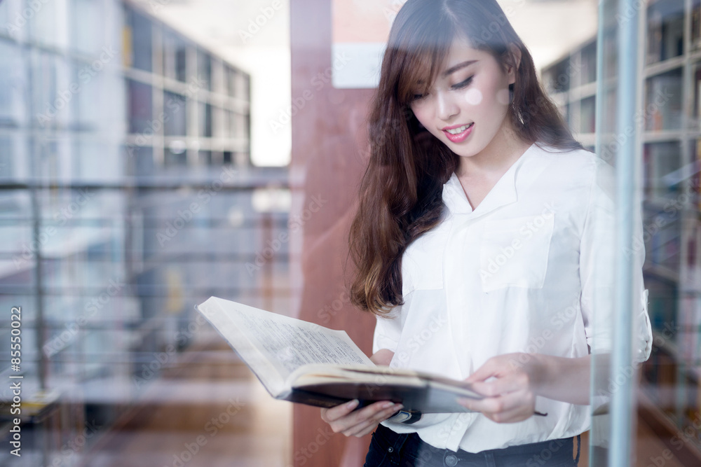 亚洲美女女学生在图书馆拿书