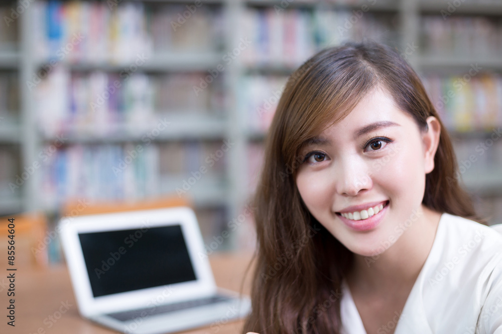 亚洲美女女学生在图书馆使用笔记本电脑