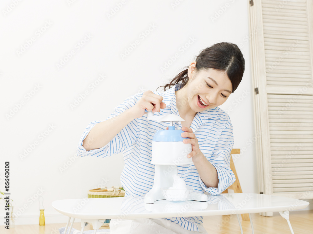 部屋でかき氷を作る女性