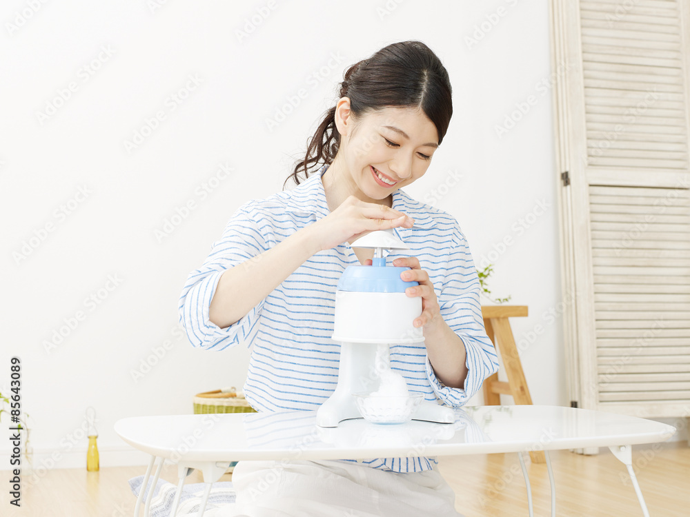 部屋でかき氷を作る女性