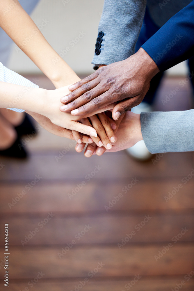 Close up of colleagues hands clasped together