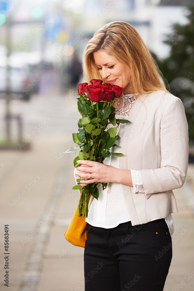 White woman smiling roses