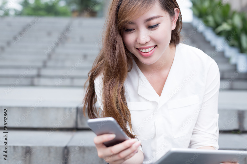 Asian beautiful female student using mobile phone in campus