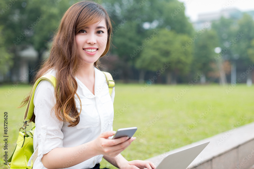 Asian beautiful female studen using mobile phone in campus