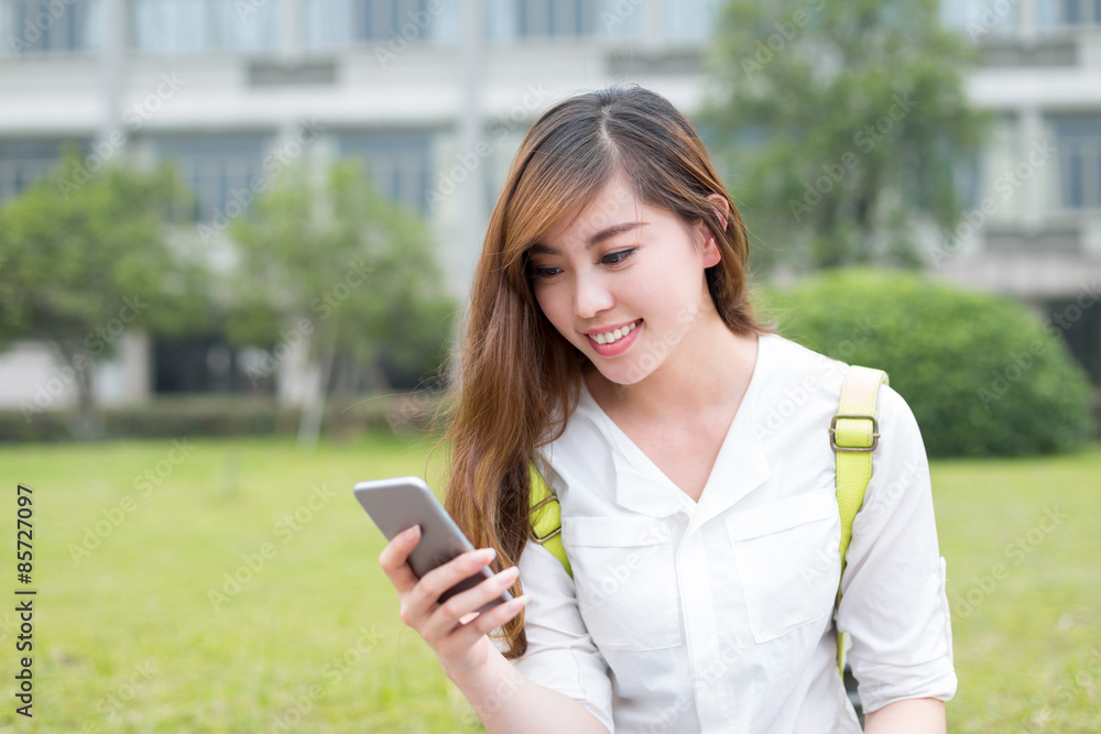 亚洲美女女学生在校园里使用手机