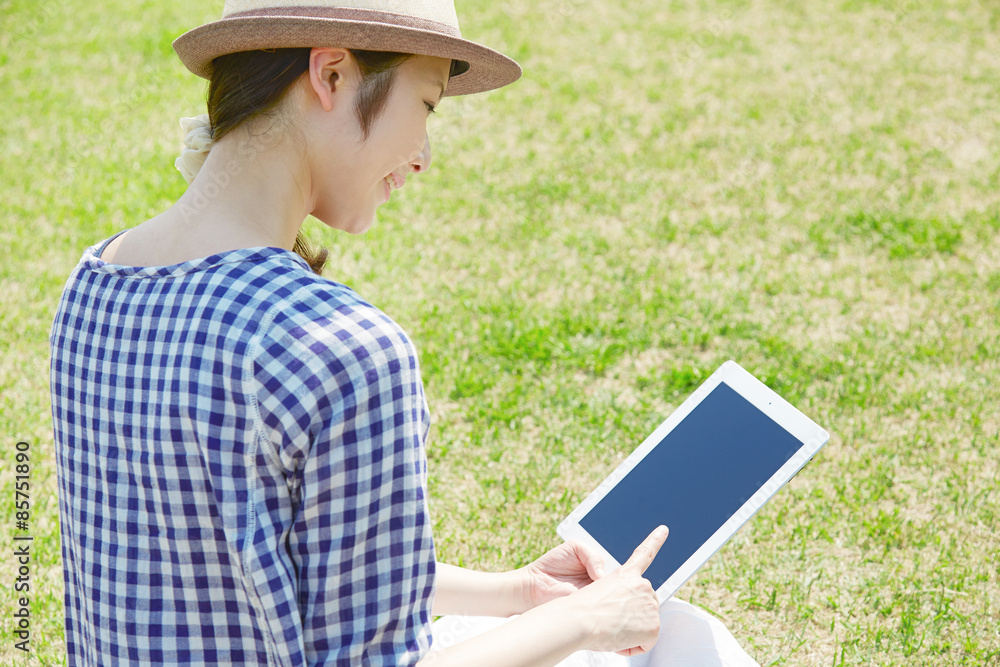 広場でタブレットを使う女性