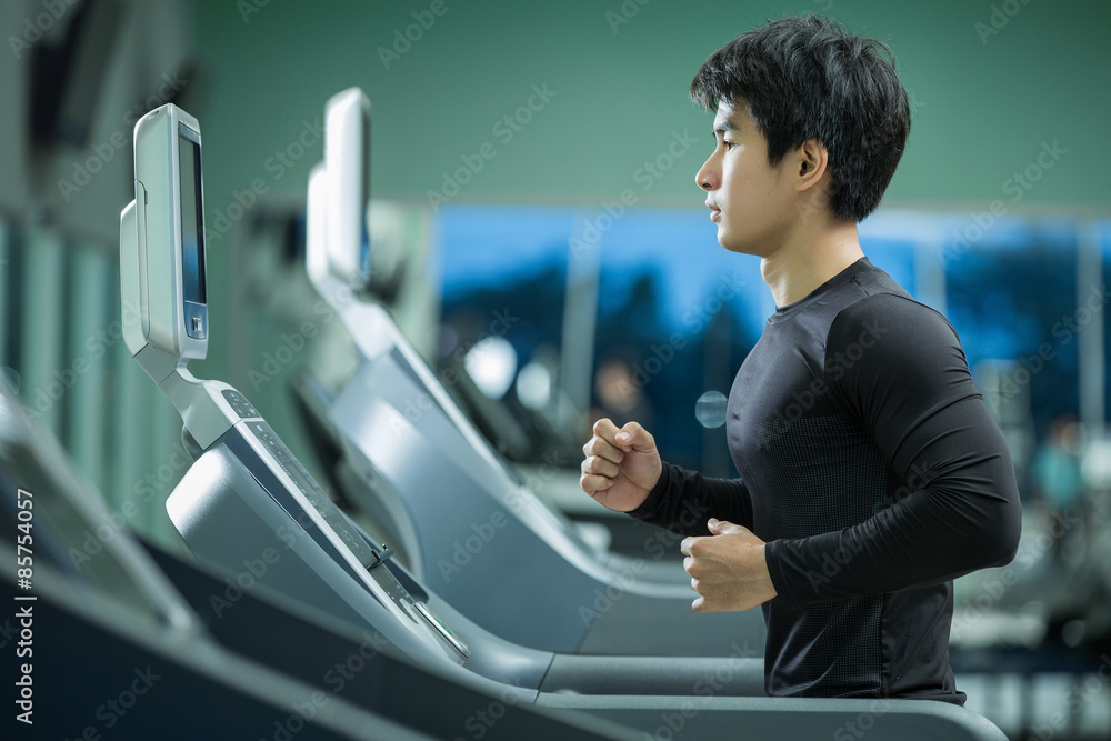 Asian man running on the treadmill in the gym