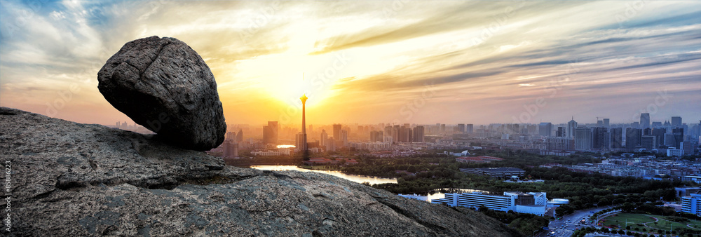 Panoramic skyline and buildings with crag on rock