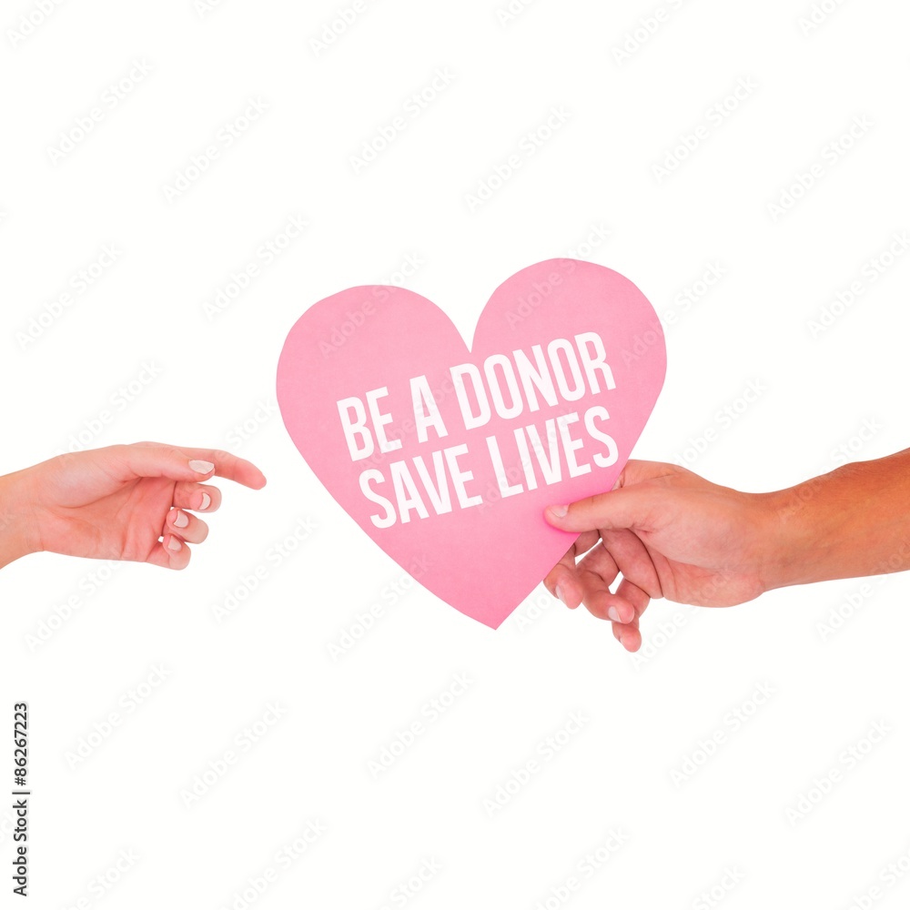 Composite image of couple passing a paper heart