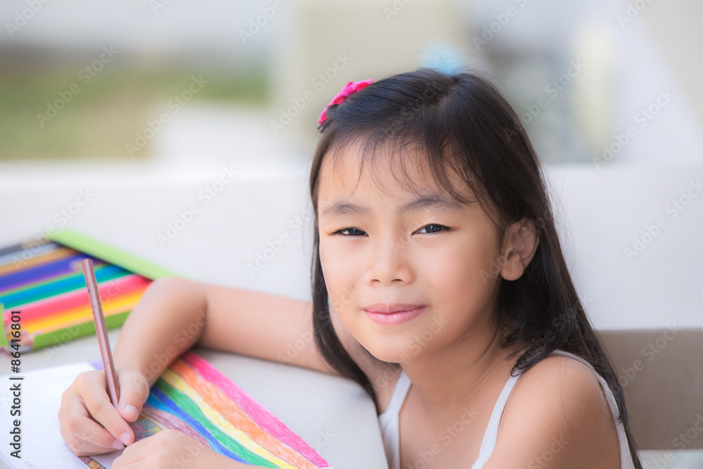 Asian Cute little girl studying and make home work at the library and smiling