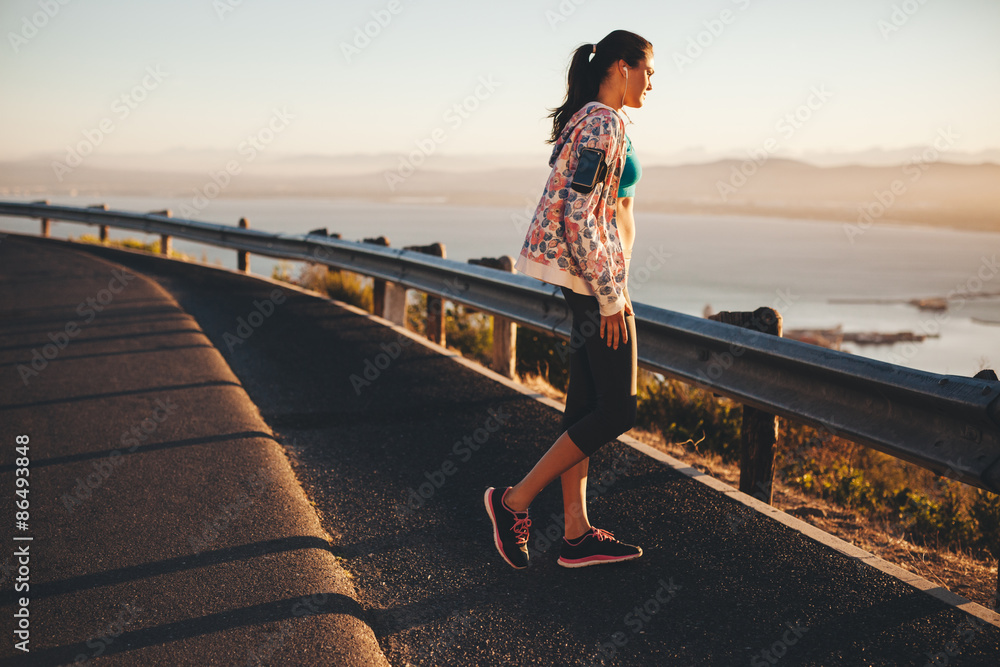 Fitness female athlete standing outdoors looking at a view