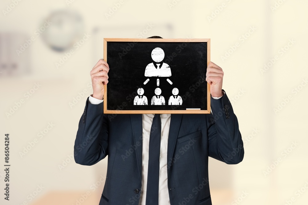 Composite image of businessman holding board