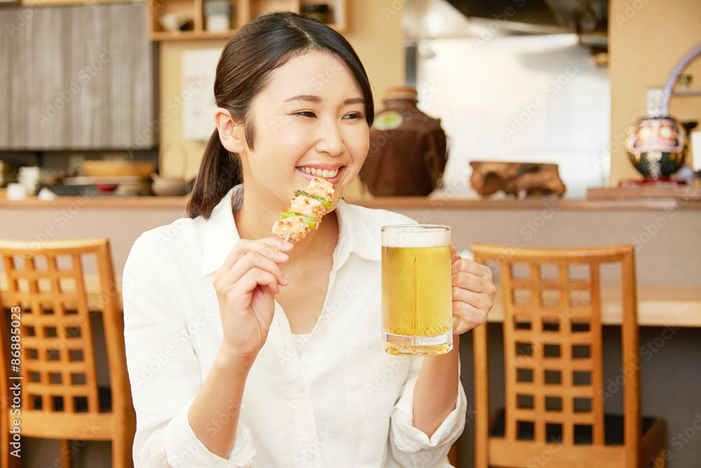 居酒屋で食事する女性