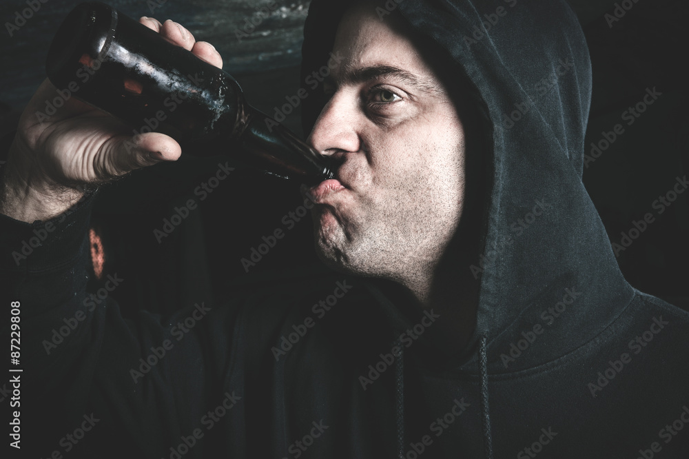 Man looks depressed with bottle in his hand.