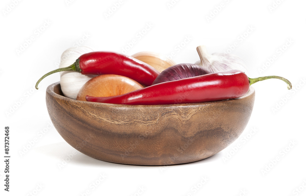 chili, onion, garlic in wooden plate isolated on white background