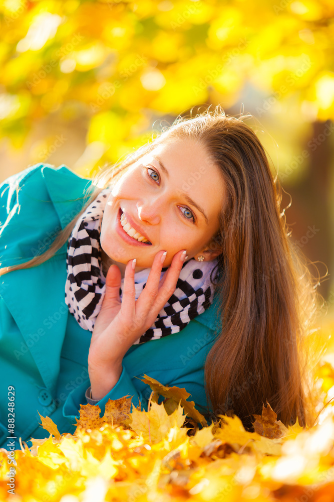 Beautiful girl lying in autumn leaves