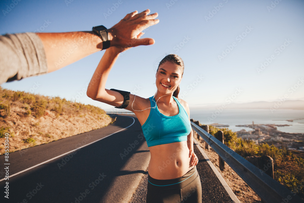 Fit young woman high fiving her boyfriend after a run