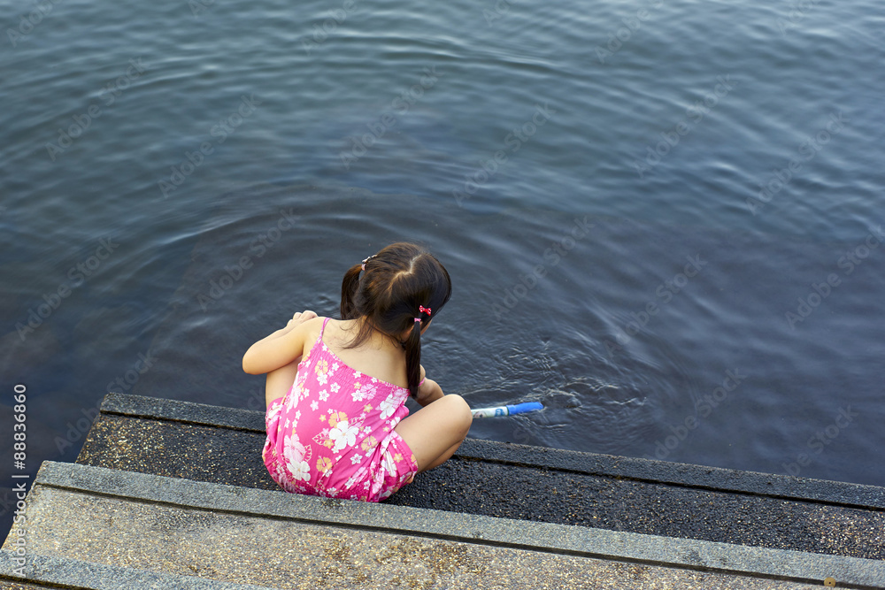 Cute little girl playing in the lake