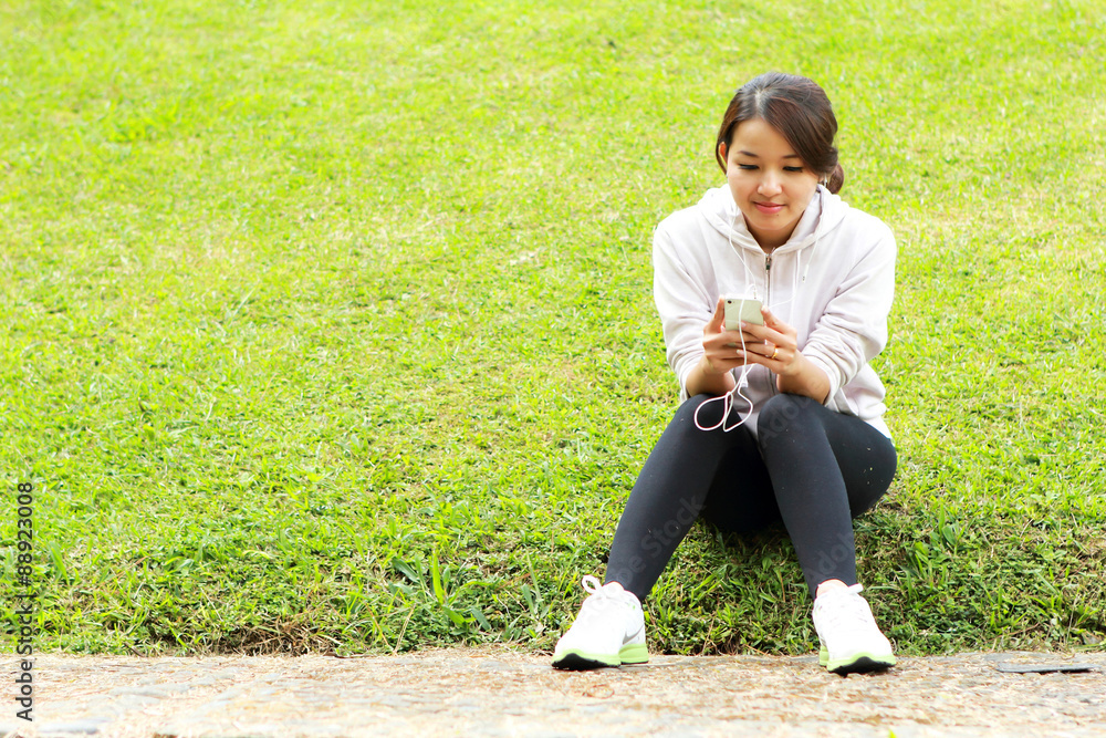 运动型女性在训练后一边听音乐一边休息