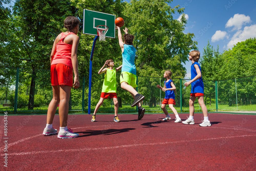 Team in colorful uniforms playing basketball game