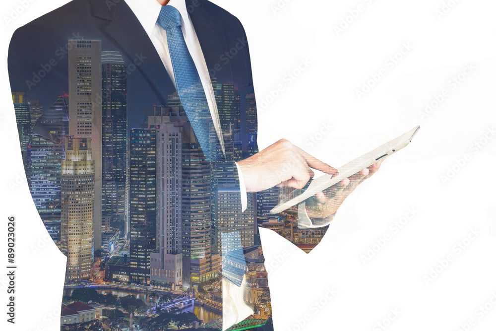 Double exposure of businessman using the tablet with cityscape