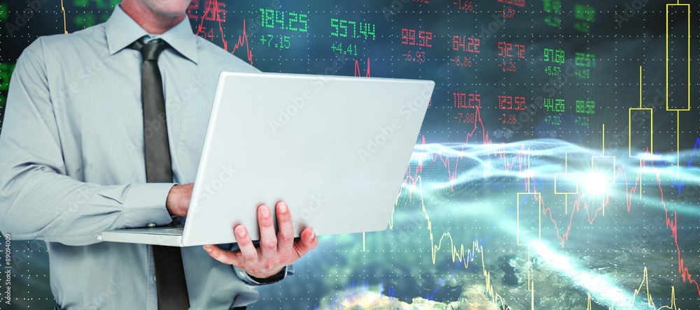 Composite image of businessman using a laptop