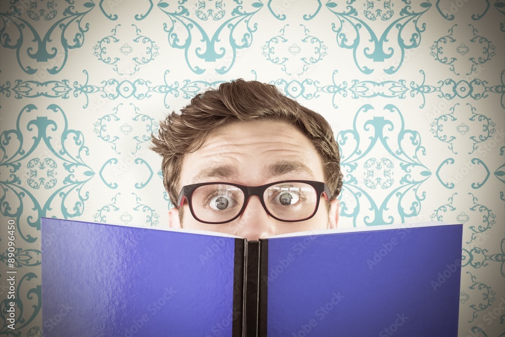 Composite image of geeky student reading a book