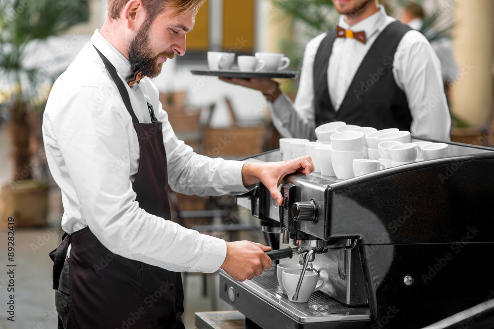 Barista making coffee with waiter 