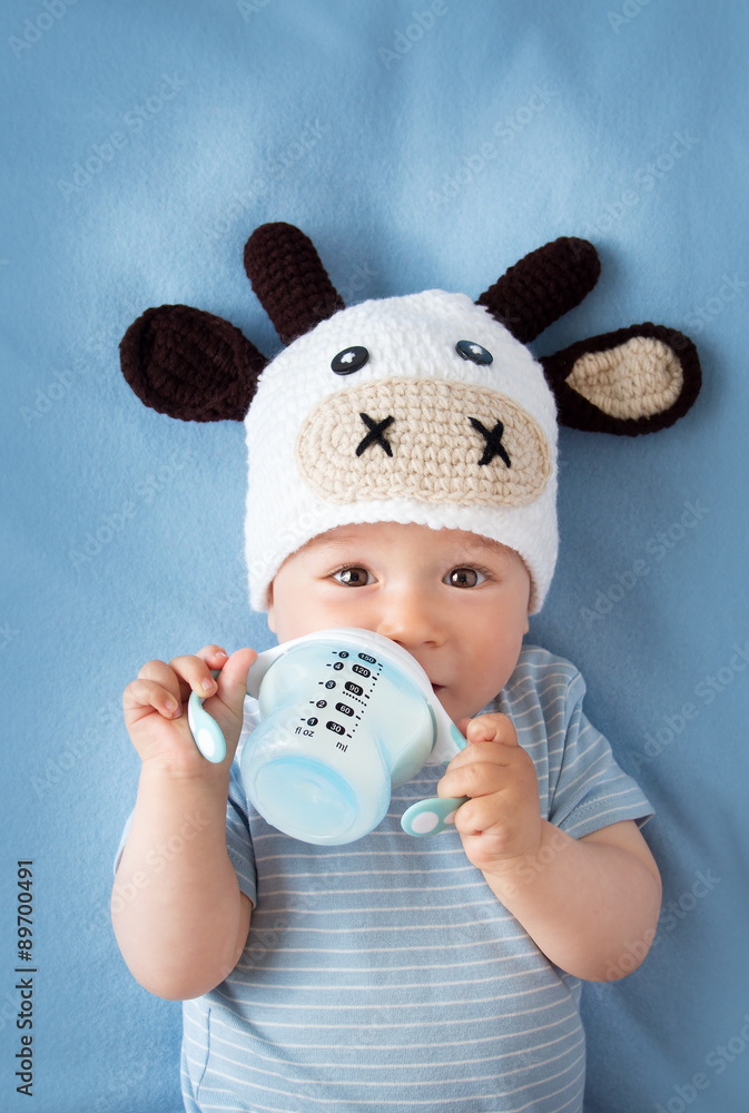 Baby in a cow hat drinking milk