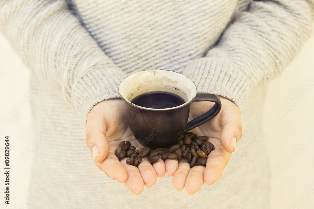 girl with cup and coffee beans in hands