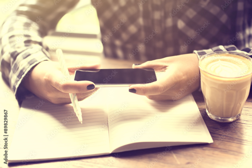 Girl with cell phone, diary and cup of coffee