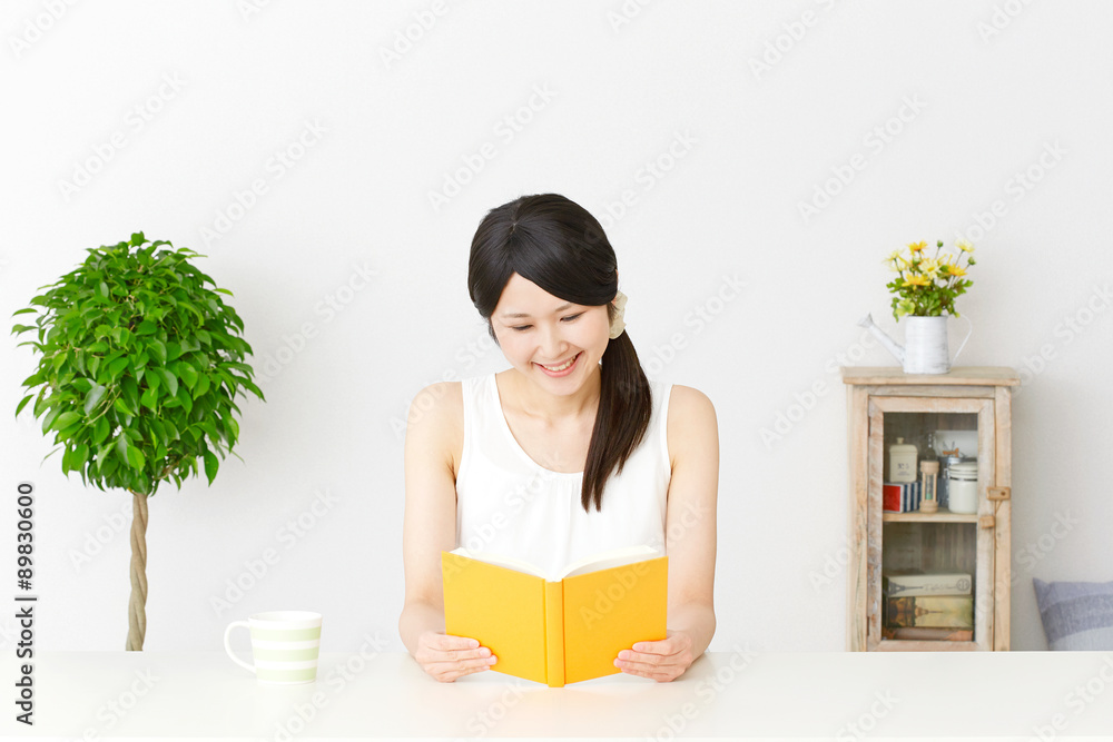 部屋で本を読む女性