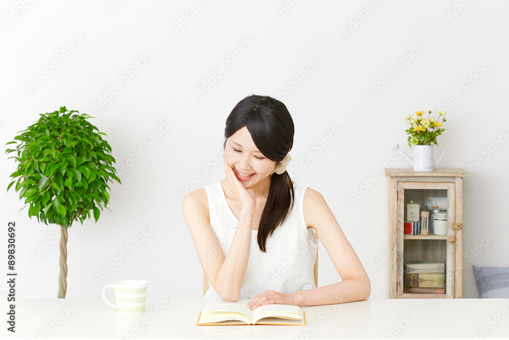 部屋で本を読む女性