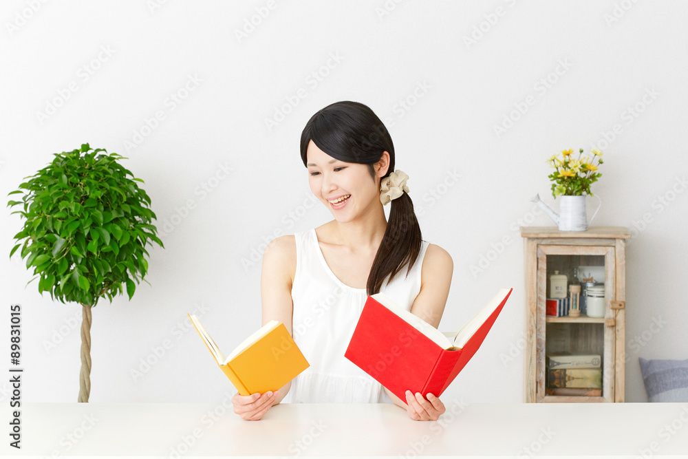 部屋で本を読む女性