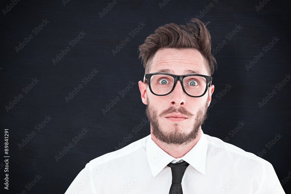 Composite image of geeky young businessman looking at camera