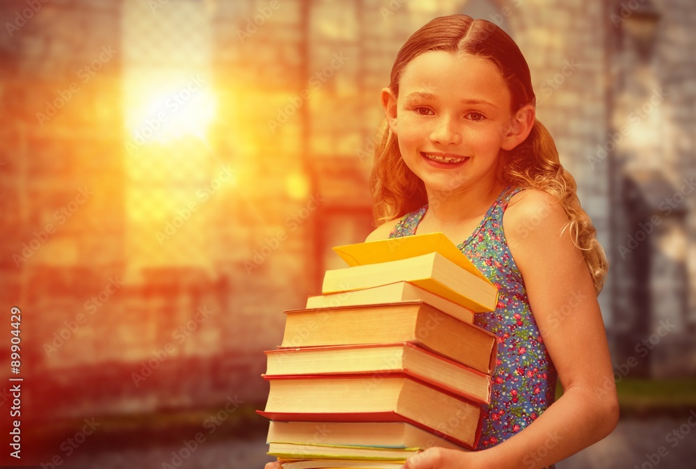 Composite image of cute little girl carrying books in library