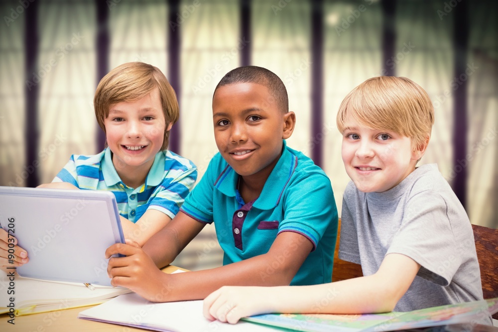 Composite image of cute pupils using tablet computer in library