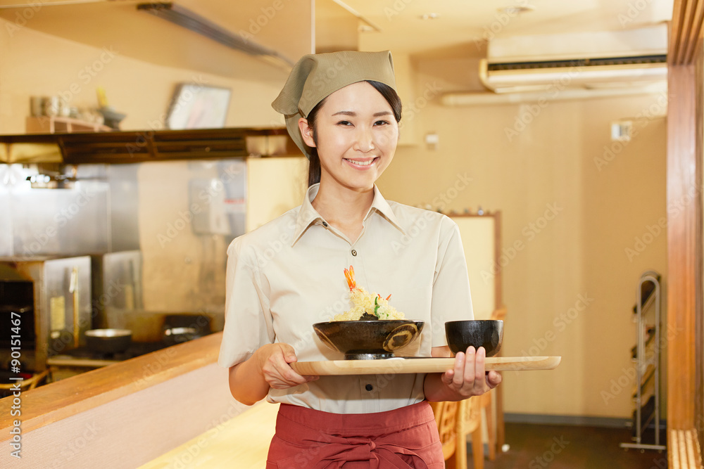 定食を運ぶ飲食店の店員