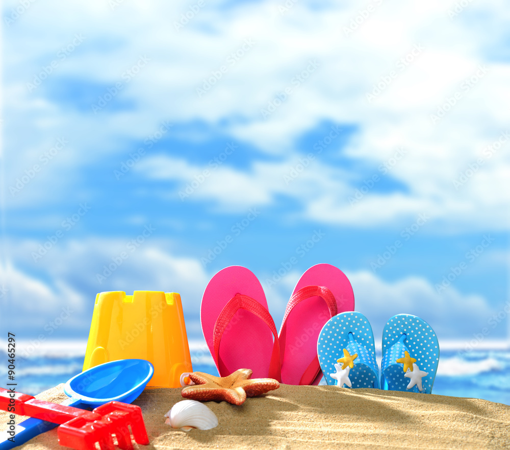 Beach accessories on sandy beach with blue sea and sky background