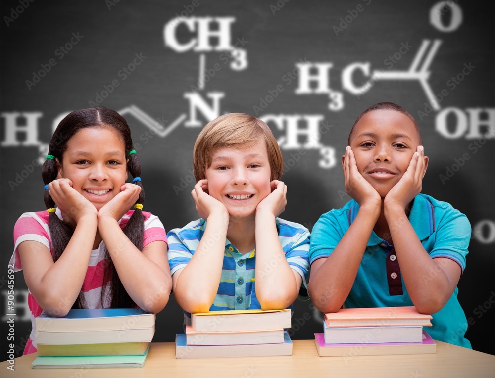 Composite image of cute pupils looking at camera in library 