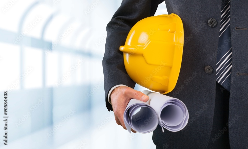 Engineer holding papers and helmet.