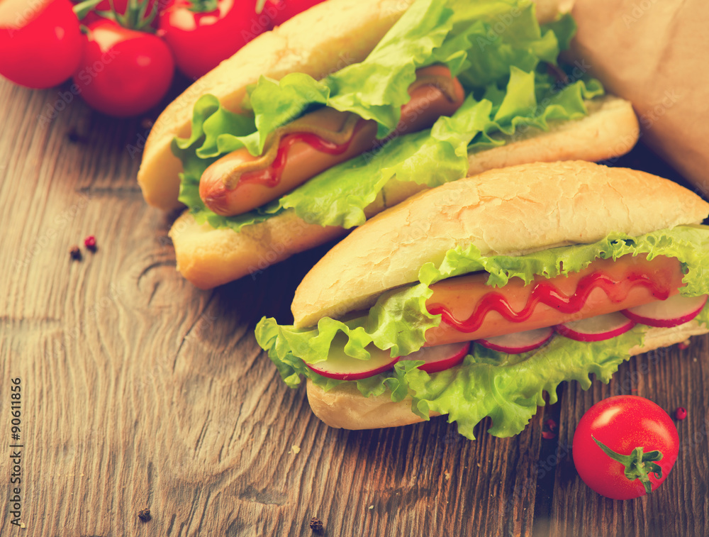 Grilled hot dogs with mustard and ketchup on a wooden table